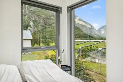 a bedroom with a window with a view of the mountains at Jordeplegarden holiday home - Part of a farm - Two buildings - Close to Flåm in Lærdalsøyri