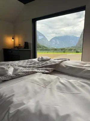 a bedroom with a large bed with a large window at Jordeplegarden holiday home - Part of a farm - Two buildings - Close to Flåm in Lærdalsøyri