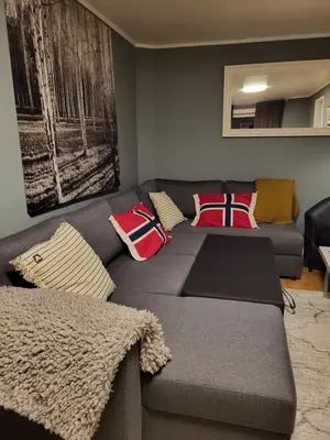 a living room with a couch with pillows on it at Ksu Nordlandet leiligheten in Kristiansund