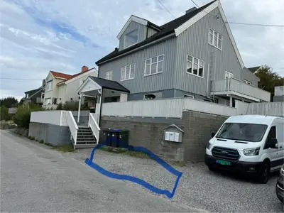 a blue hose is sitting in front of a house at Ksu Nordlandet leiligheten in Kristiansund