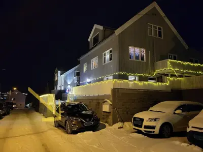 two cars parked in front of a house with christmas lights at Ksu Nordlandet leiligheten in Kristiansund