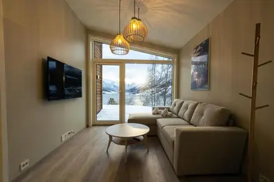 a living room with a couch and a table and a window at Leilighet med utsikt i Loen in Stryn