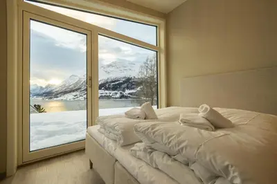 a bedroom with a large window with snow covered mountains at Leilighet med utsikt i Loen in Stryn