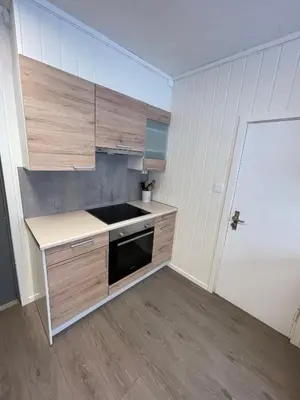 a kitchen with wooden cabinets and a black microwave at Spacious house in Trysil in Trysil