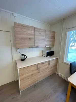 a kitchen with wooden cabinets and a microwave at Spacious house in Trysil in Trysil