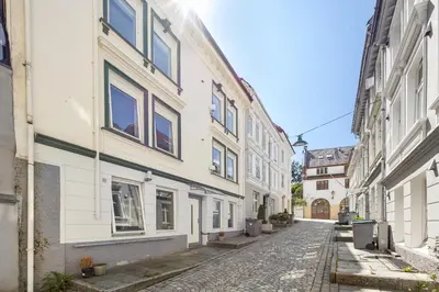 an empty street in an alley with buildings at Renovated jan 24 - Queen beds - Behind Bryggen in Bergen