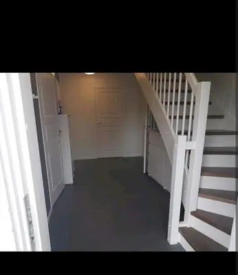 an empty room with a staircase and a door at Hus ved sjøen in Bakken