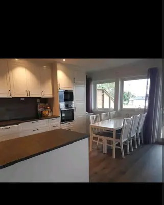 a kitchen and dining room with a table and chairs at Hus ved sjøen in Bakken
