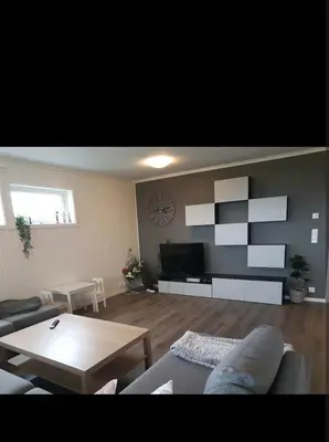 a living room with a couch and a table at Hus ved sjøen in Bakken