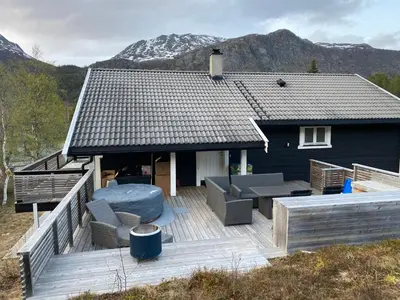 a house with a deck with furniture and a roof at 2 mannsbolig i Hemsedal sentrum, nær skianlegget - 3 sov og 7 sengeplasser in Hemsedal