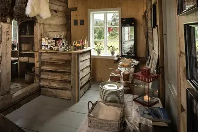 a room with wooden walls and a counter with plates at Flatheim in Viksdalen