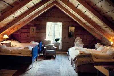 a attic room with two beds and a window at Flatheim in Viksdalen