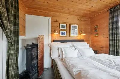 a living room with a couch and a stove at Flatheim in Viksdalen