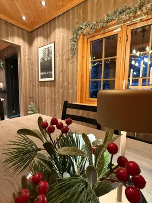 a table with a vase of red berries on it at Trysil Moderna Lodge in Trysil
