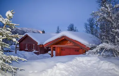 a red barn covered in snow with snow covered trees at Lovely Home In Geilo With Wifi in Geilo