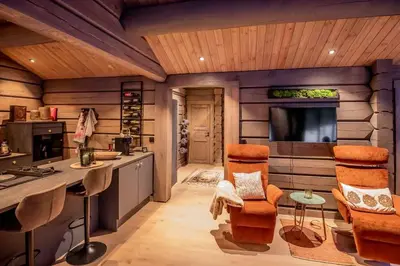 a kitchen with a counter and chairs in a room at ElveRo Lodge in Trysil
