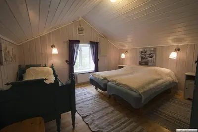 a attic bedroom with two beds and a window at Edvinstua Solbakken Feriehus in Fevåg