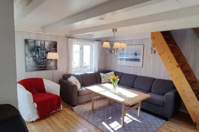a living room with a couch and a table at Edvinstua Solbakken Feriehus in Fevåg