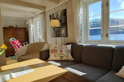 a living room with a couch and a table at Edvinstua Solbakken Feriehus in Fevåg