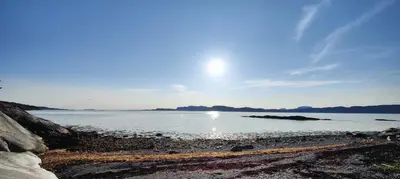a body of water with the sun in the sky at Apartment Solbakken Feriehus in Fevåg