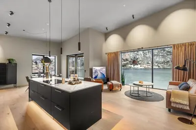 a kitchen with a large island and a living room at Toppleilighet på bryggen i Sogndal med fantastisk utsikt in Sogndal