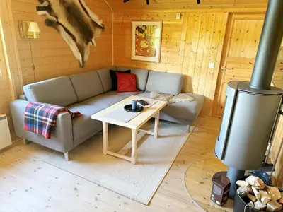 a living room with a couch and a table at Kinnkosen - cabin with panoramic view for 6 persons in Ål