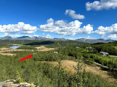 a red object in a field with mountains in the background at Kinnkosen - cabin with panoramic view for 6 persons in Ål