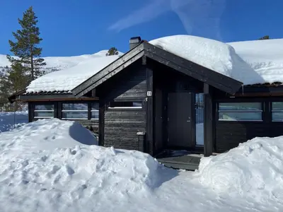 a snow covered cabin with a pile of snow at Hito - cabin between Flå and Eggedal in Flå