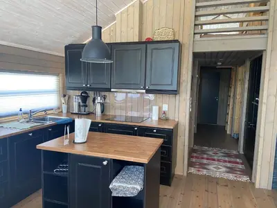 a kitchen with blue cabinets and a wooden floor at Hito - cabin between Flå and Eggedal in Flå