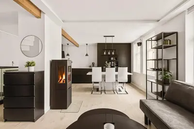 a living room with a fireplace and a dining room at Bryggen Hideaway I Lux Feeling & Private Patio in Bergen
