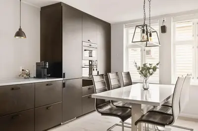 a kitchen with a dining room table and chairs at Bryggen Hideaway I Lux Feeling & Private Patio in Bergen