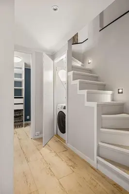a staircase in a white room with a washing machine at Bryggen Hideaway I Lux Feeling & Private Patio in Bergen