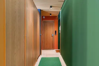 a hallway with orange and green walls and a door at Unique gem overlooking the world famous Bryggen in Bergen