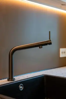 a bathroom sink with a metal faucet over a counter at Fresh studio apartment, a short walk from Bryggen in Bergen