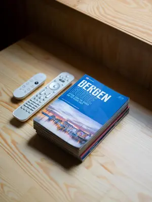 a book and two remote controls sitting on a table at Unique Studio I Custom Built I 500 Meters From Bryggen in Bergen