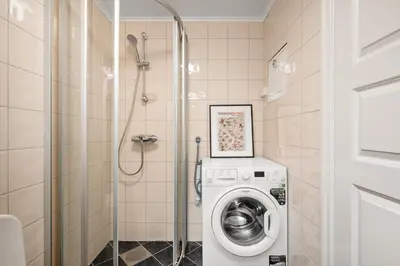 a bathroom with a washing machine and a shower at Unique Studio I Custom Built I 500 Meters From Bryggen in Bergen