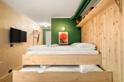 a bedroom with two beds and a flat screen tv at Unique Studio I Custom Built I 500 Meters From Bryggen in Bergen