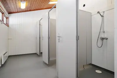 a row of stalls in a bathroom with white walls at Utladalen Camping in Årdal