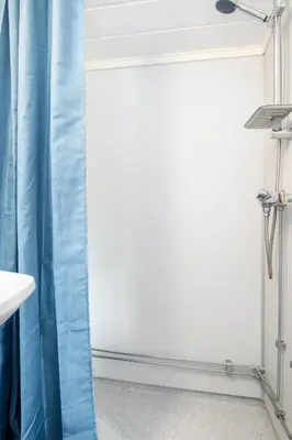 a bathroom with a blue shower curtain and a sink at Utladalen Camping in Årdal