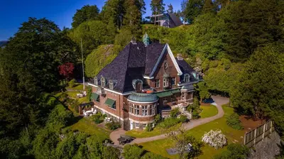 an aerial view of a large house on a hill at Luxury Historic Villa with private coastline in Bergen