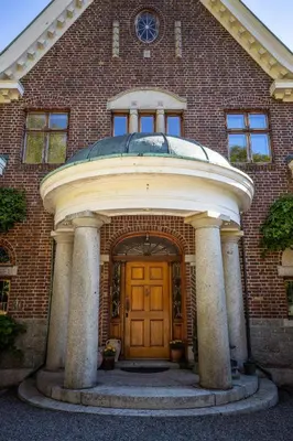 a brick building with a wooden door in front at Luxury Historic Villa with private coastline in Bergen