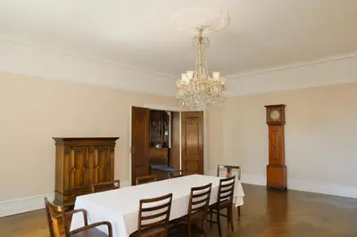 a dining room with a white table and a chandelier at Luxury Historic Villa with private coastline in Bergen