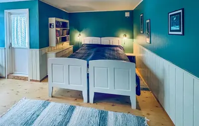 a bedroom with a white bed in a blue wall at Amazing Home In Svingvoll in Svingvoll