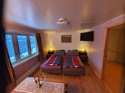 a bedroom with a bed and a television in it at Overnatting Rodal in Valsøybotn