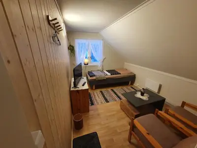 a small room with a bed and a couch at Overnatting Rodal in Valsøybotn