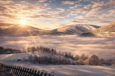 a view of a foggy valley with the sun rising over the mountains at Smie på sjarmerende og historisk gård in Baukål