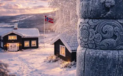 a house in the snow with a canadian flag at Sjarmerende tømmerhytte på gårdstun in Baukål