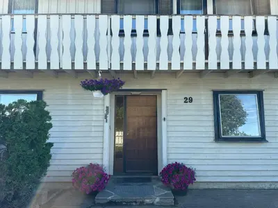 a house with a wooden door with flowers on it at Lovely fully furnished apartment in Ottestad