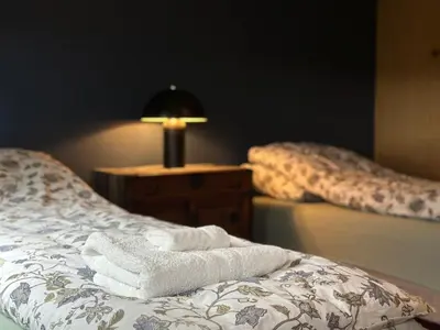 a bed with towels on it with a lamp on a table at Lovely fully furnished apartment in Ottestad