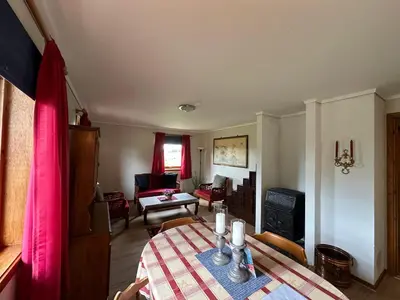 a living room with a table and a living room with a room at Lovely fully furnished apartment in Ottestad